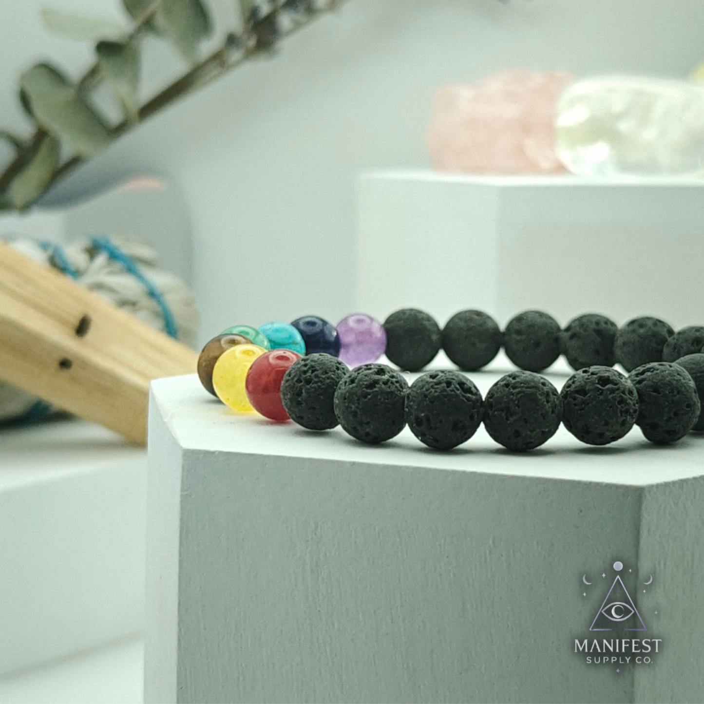 Black beaded bracelet with multicolored beads on a white box, featuring the Manifest brand.