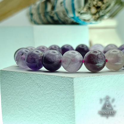 Amethyst purple bracelet on a light blue surface with a blurred background