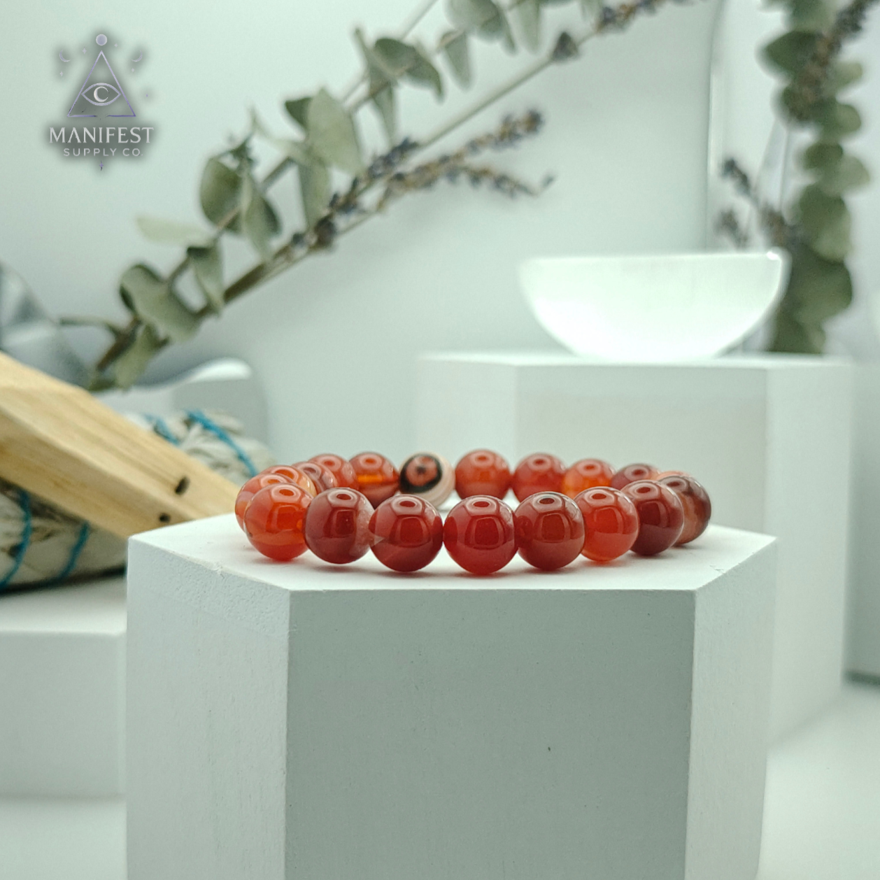 Decorative red beads on a white pedestal with a blurred background