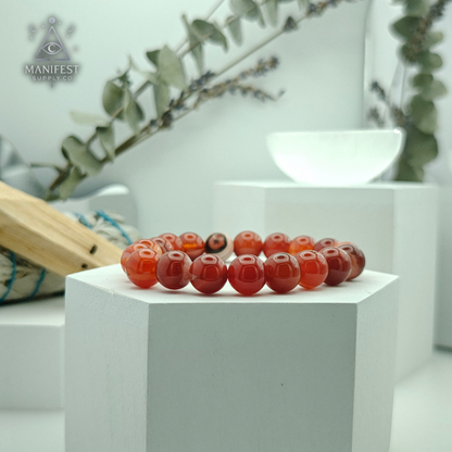 Decorative red beads on a white pedestal with a blurred background