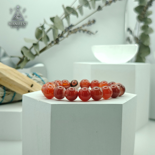 Decorative red beads on a white pedestal with a blurred background