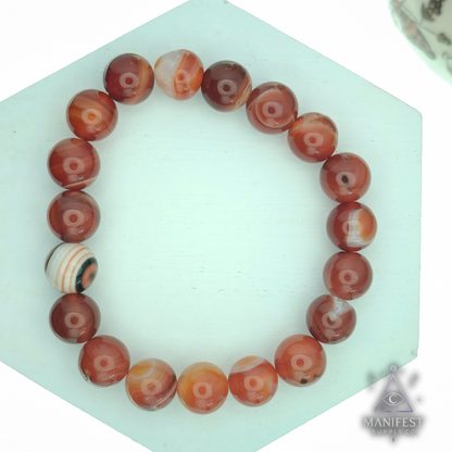 Beaded bracelet on a hexagonal green stand with a white background