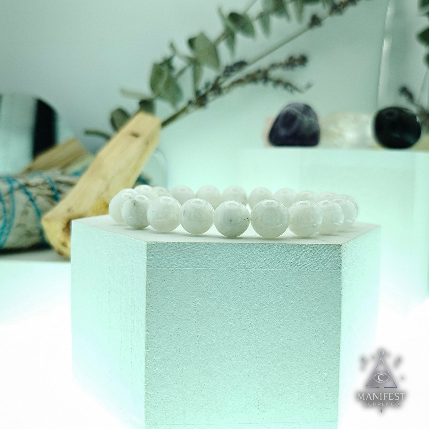 Rainbow Moonstone  beaded bracelet on a light green block with a blurred background