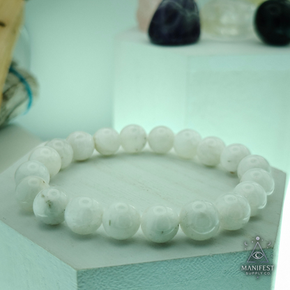 Multicolored beaded bracelet on a white pedestal with a blurred natural background