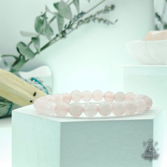 RoseQuartz Pink beaded bracelet on a white stand with a light green background
