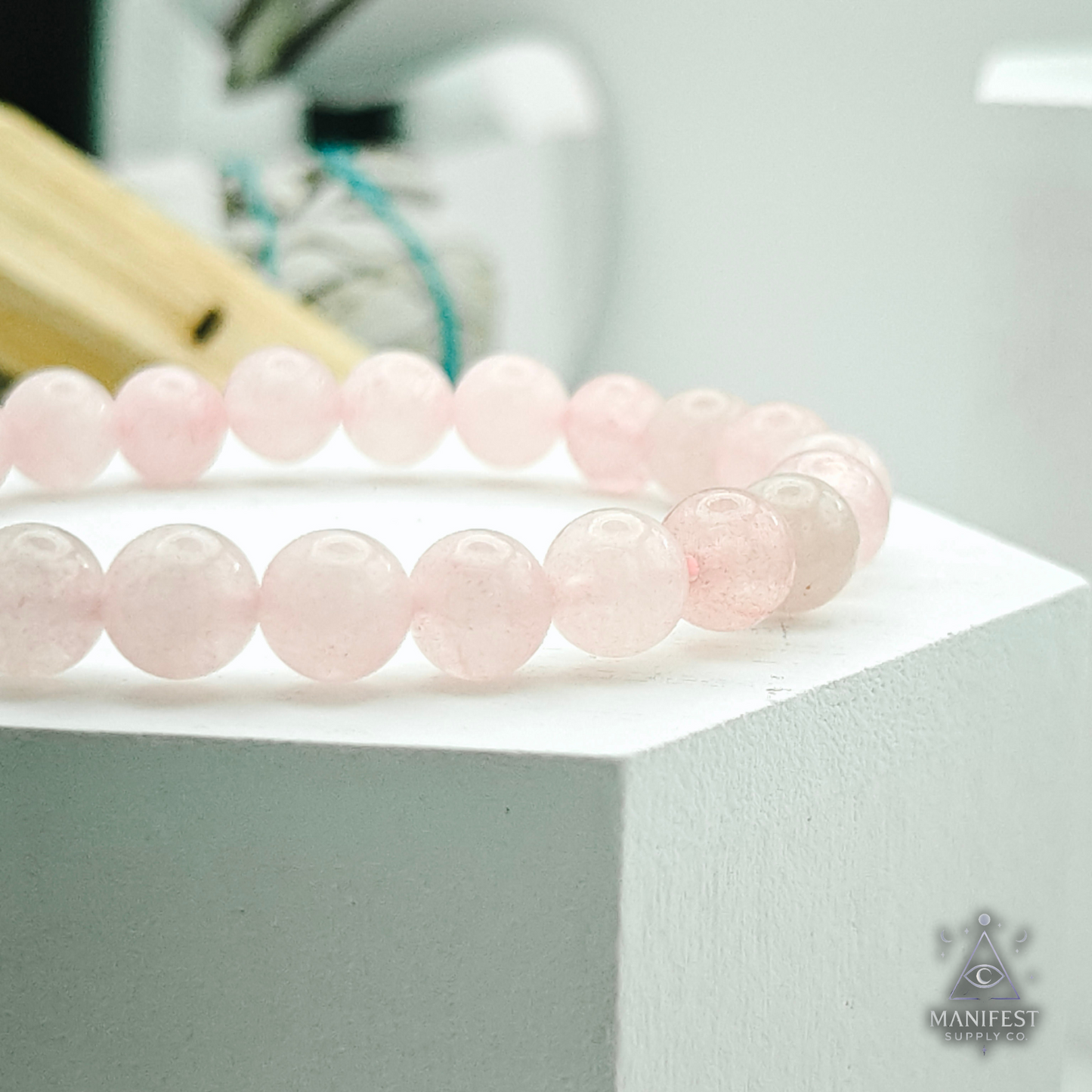 Rose Quartz Pink beaded bracelet on a white surface with a blurred background