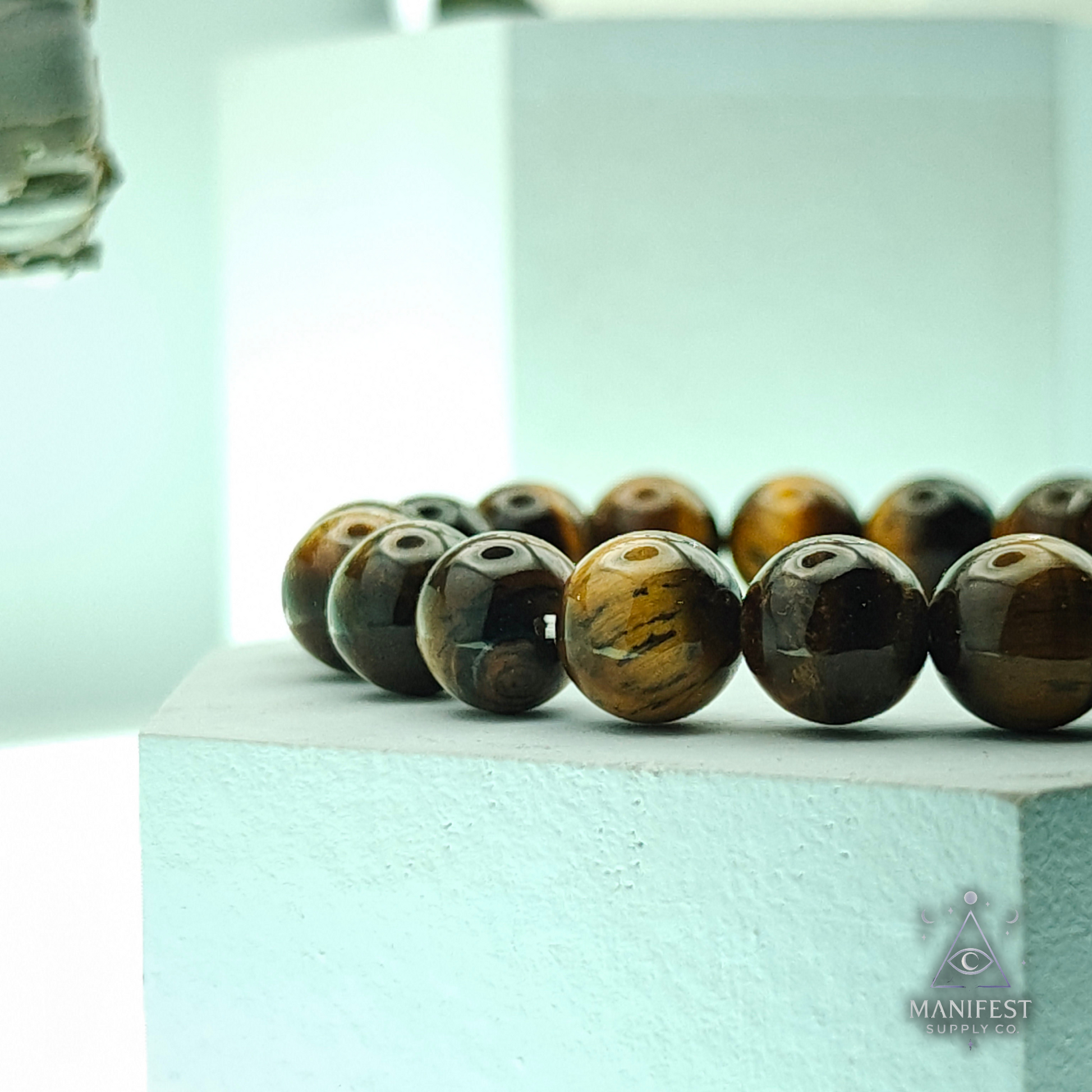 Beaded bracelet with tiger eye beads on a light blue background